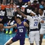 Jan 20, 2025; Charlotte, North Carolina, USA; Charlotte Hornets guard Josh Green (10) passes as he is guarded by Mavs center Daniel Gafford (21) during the first half at the Spectrum Center.